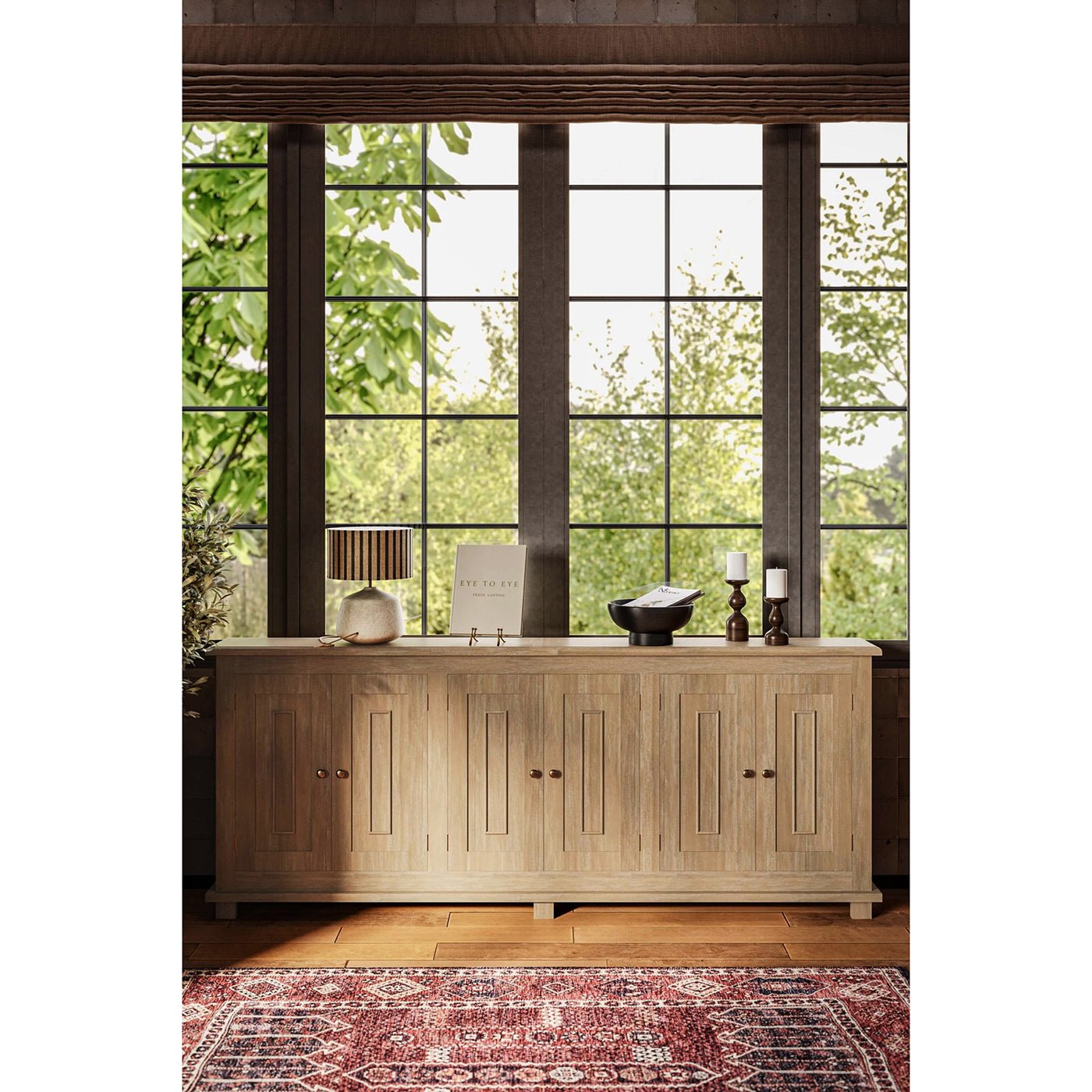 Sideboard in room with large windows and décor.