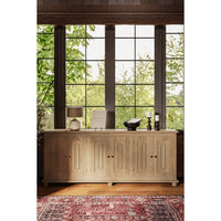 Sideboard in room with large windows and décor.