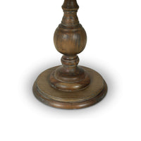 Close-up of pedestal end table base, turned wood design.