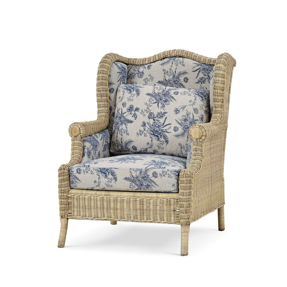 Rattan wingback armchair with blue floral cushions.