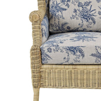 Armrest and seat detail of wicker wingback chair.