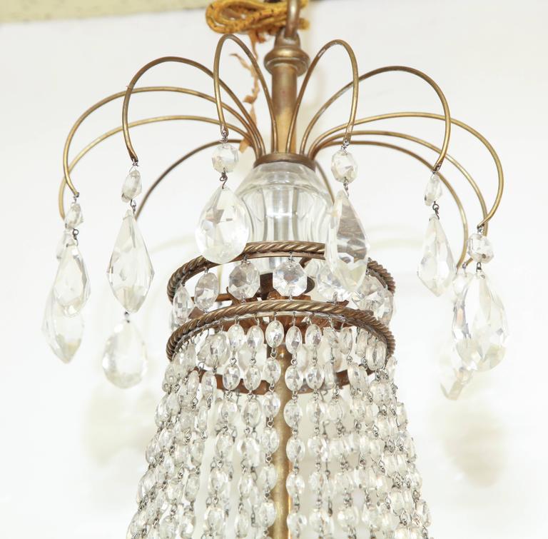 Top section of chandelier with hanging crystals.