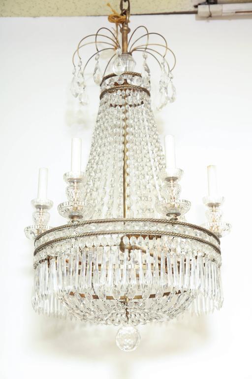 French chandelier close-up, six lights, detailed crystals.