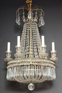 Chandelier with crystals lit in dark background, dramatic effect.