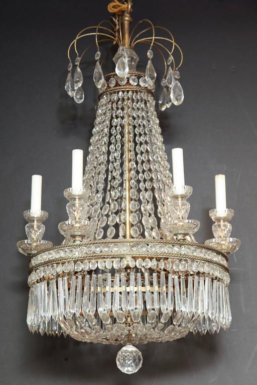 Chandelier with crystals lit in dark background, dramatic effect.