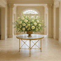 Ornate center table with floral arrangement, bright hallway.