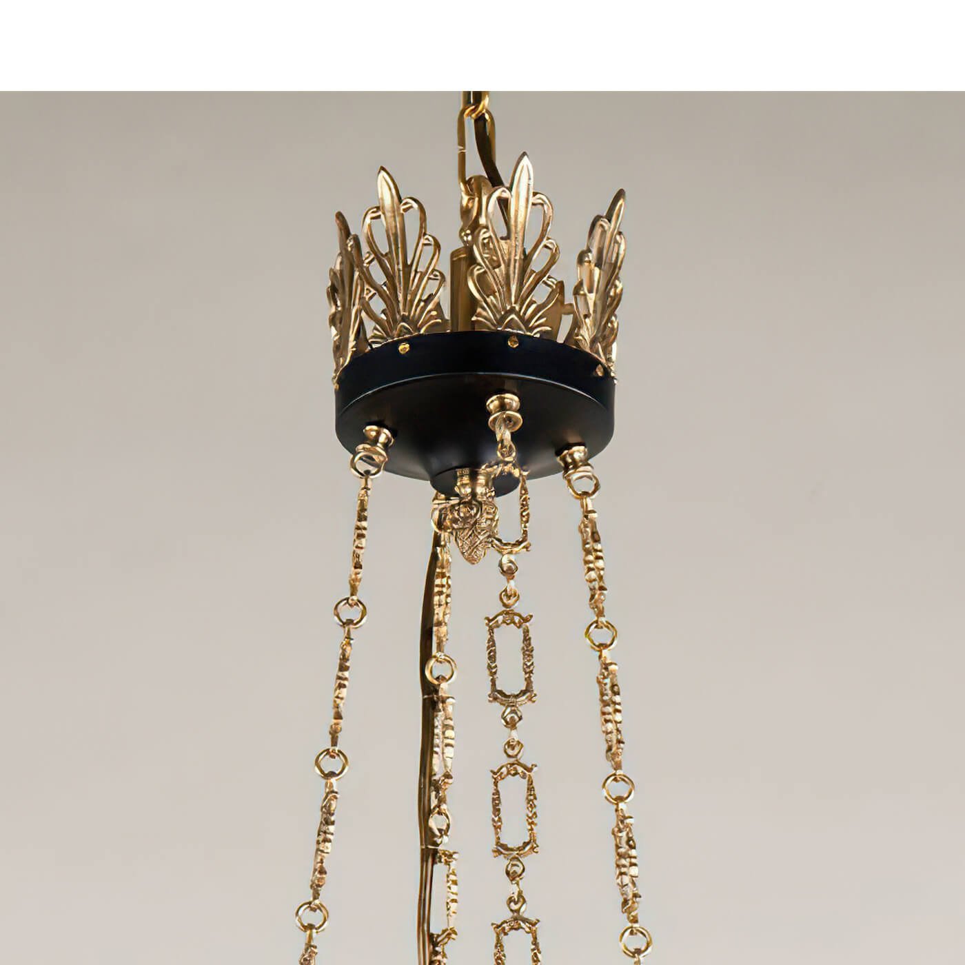 Close-up of gold chain and crown detail on chandelier.