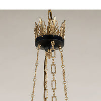 Close-up of gold chain and crown detail on chandelier.