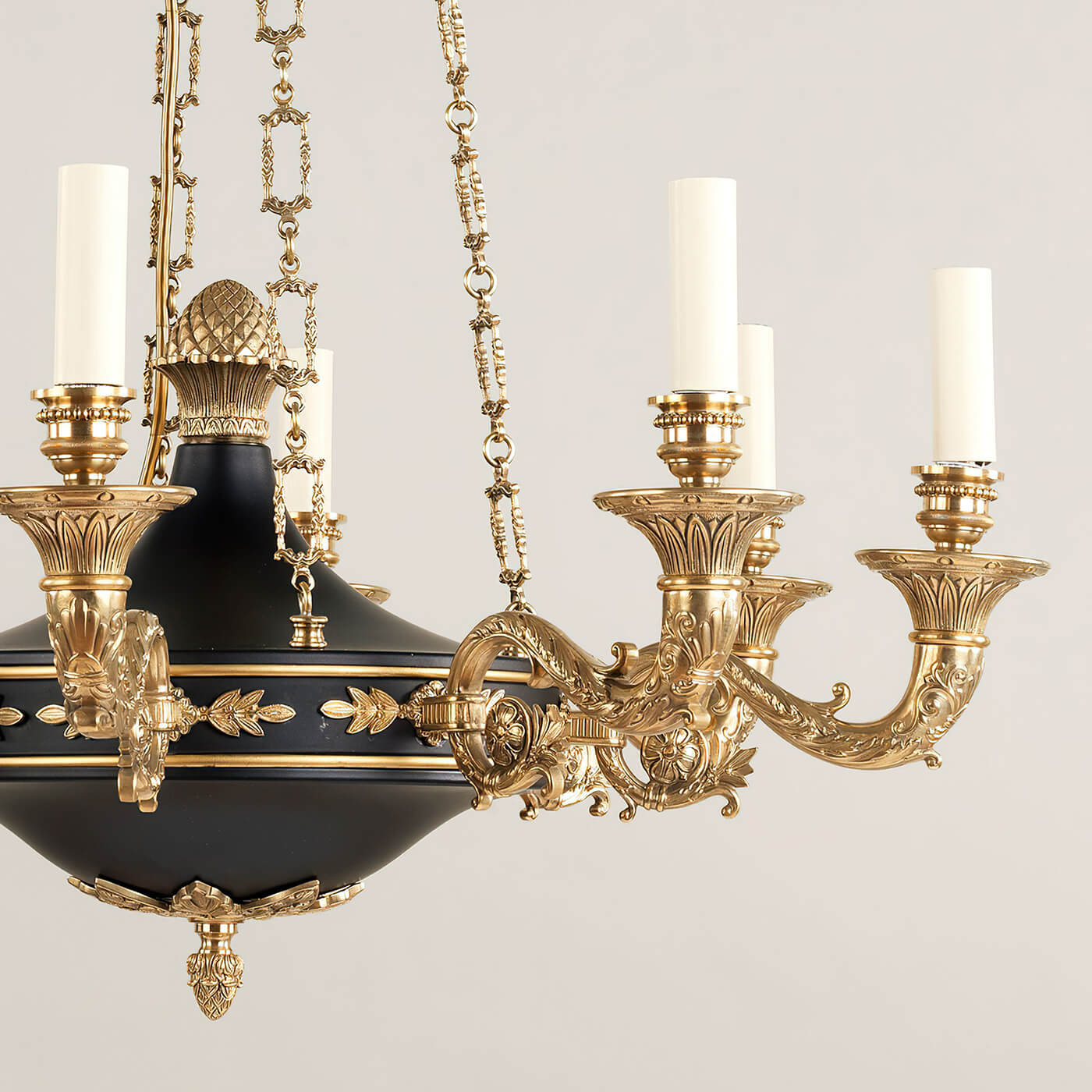 Detailed view of chandelier's ornate arms and candle lights.