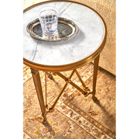 Round accent table with glass and silver tray on top.