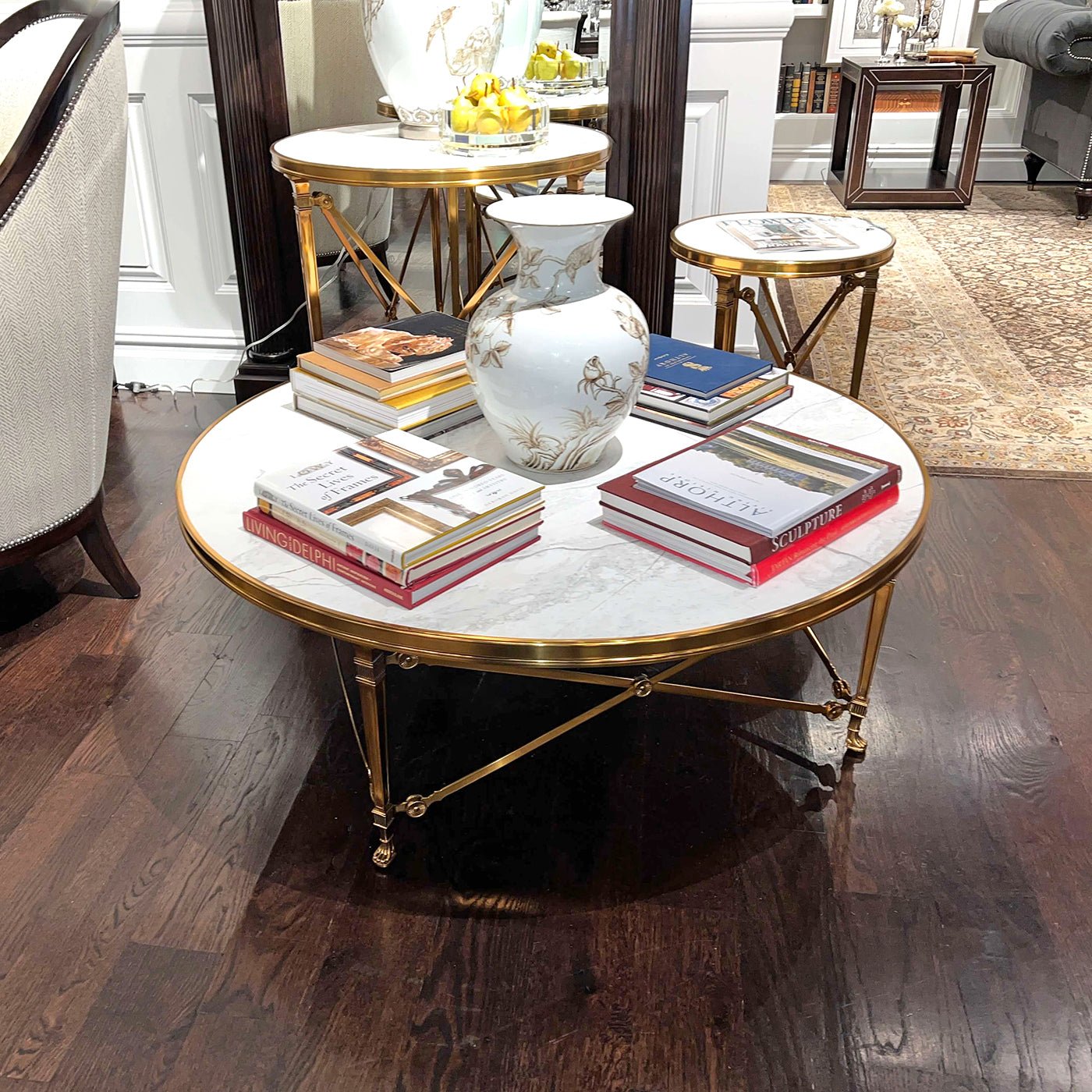 Marble-topped round tables displaying books, vase in living area.