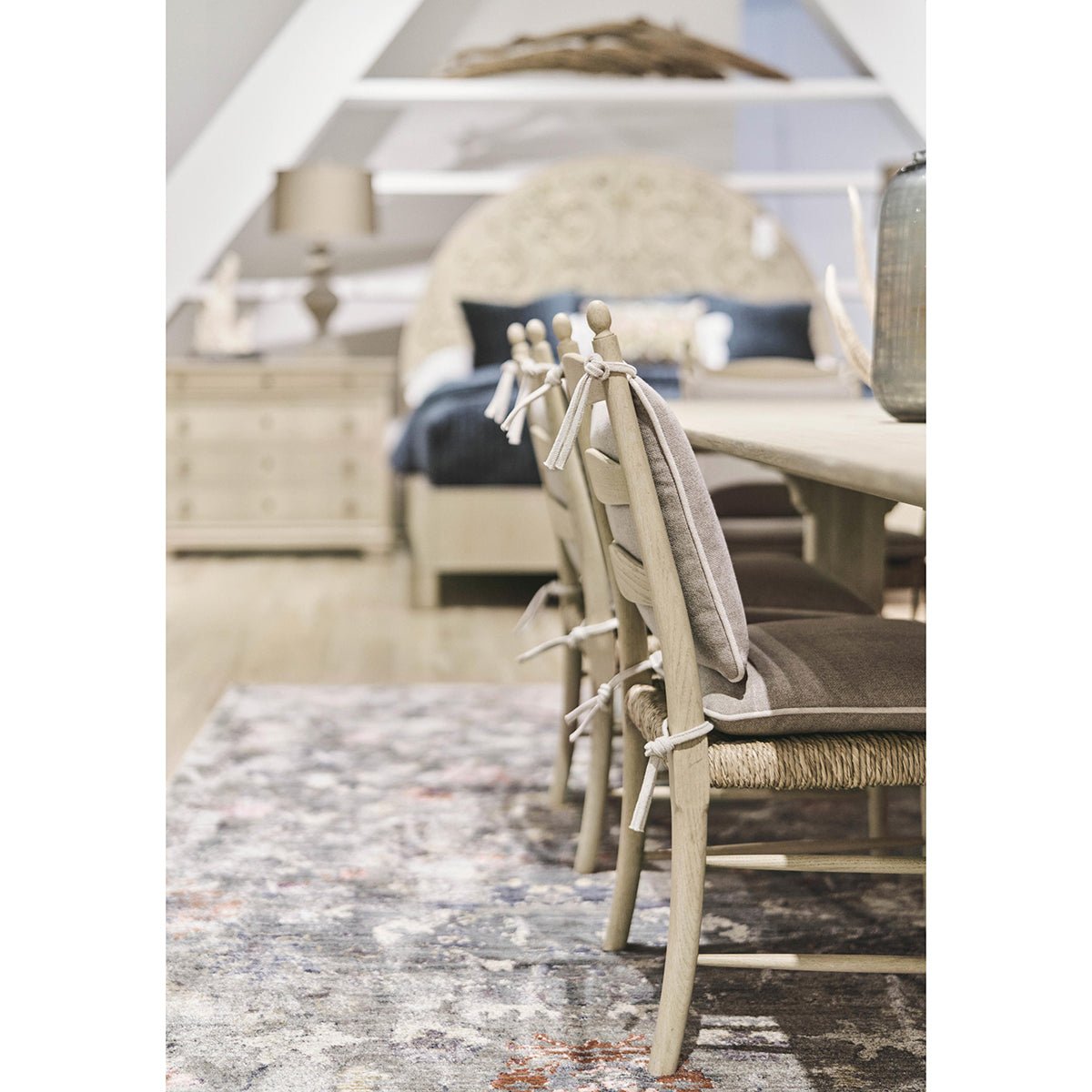 Ladderback chairs along dining table in cozy room.