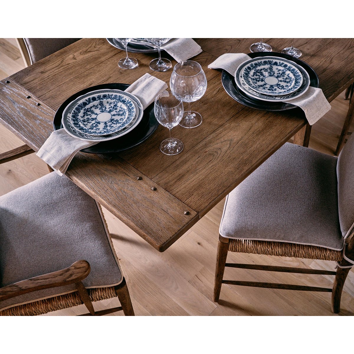 Close-up dining table corner, ladderback chairs detail.