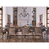 Dining room with multiple ladderback chairs around table.