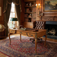 Writing desk in classic library setting with leather chair.