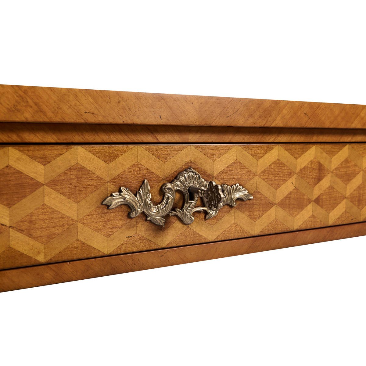 Detailed view of ornate metal handle on writing desk drawer.