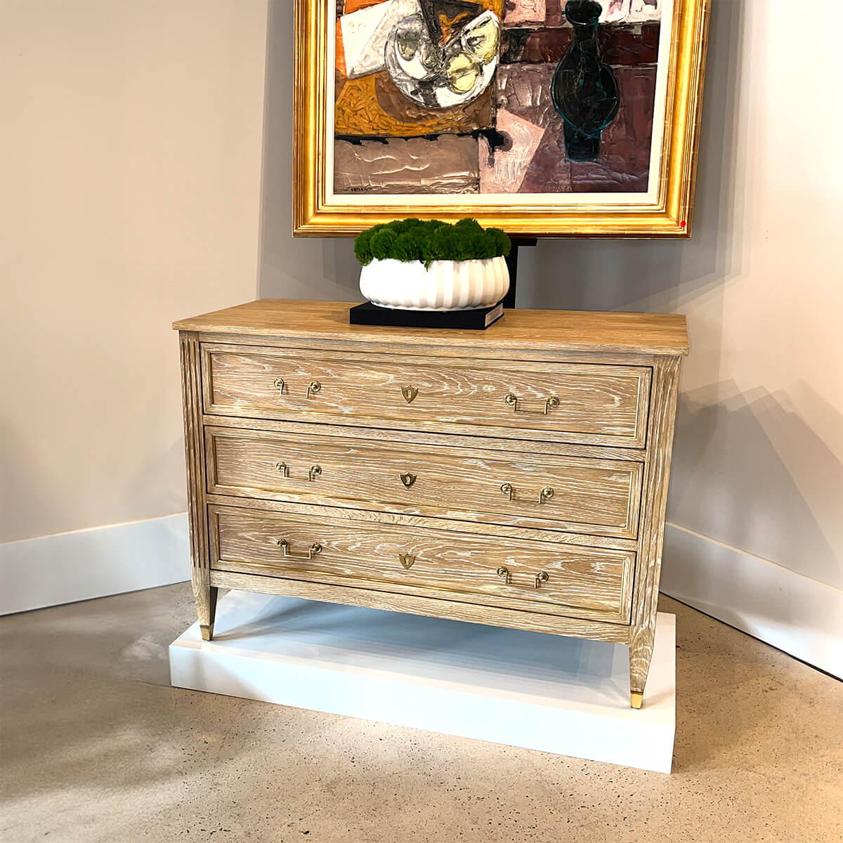 French Louis XVI chest styled in modern room, with art.