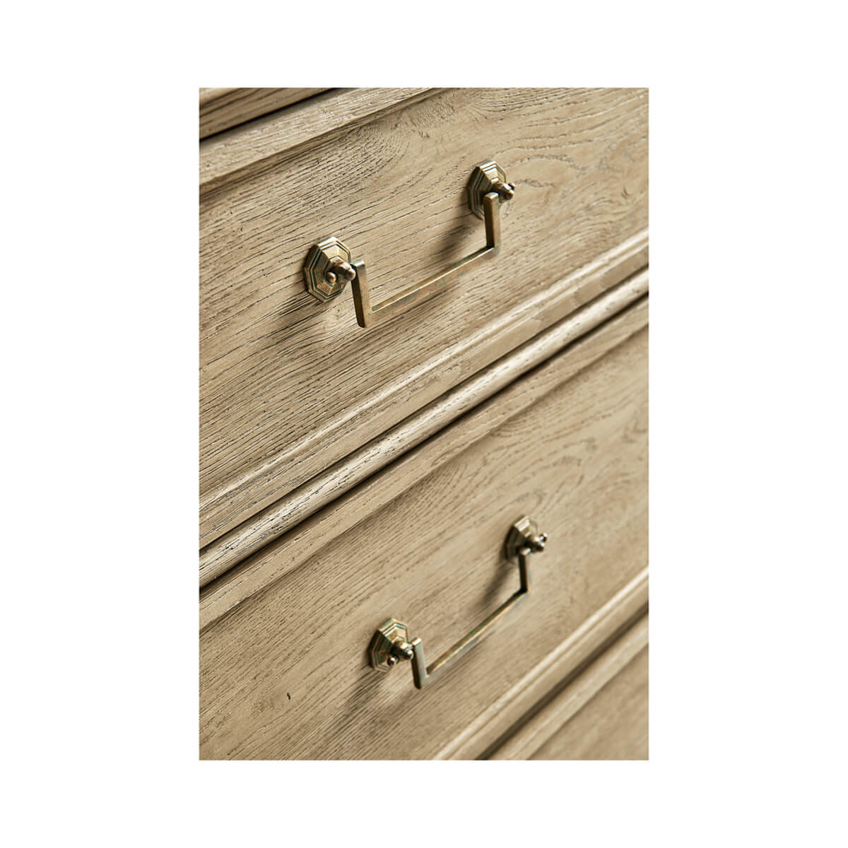 Detailed drawer handles on natural wood commode.