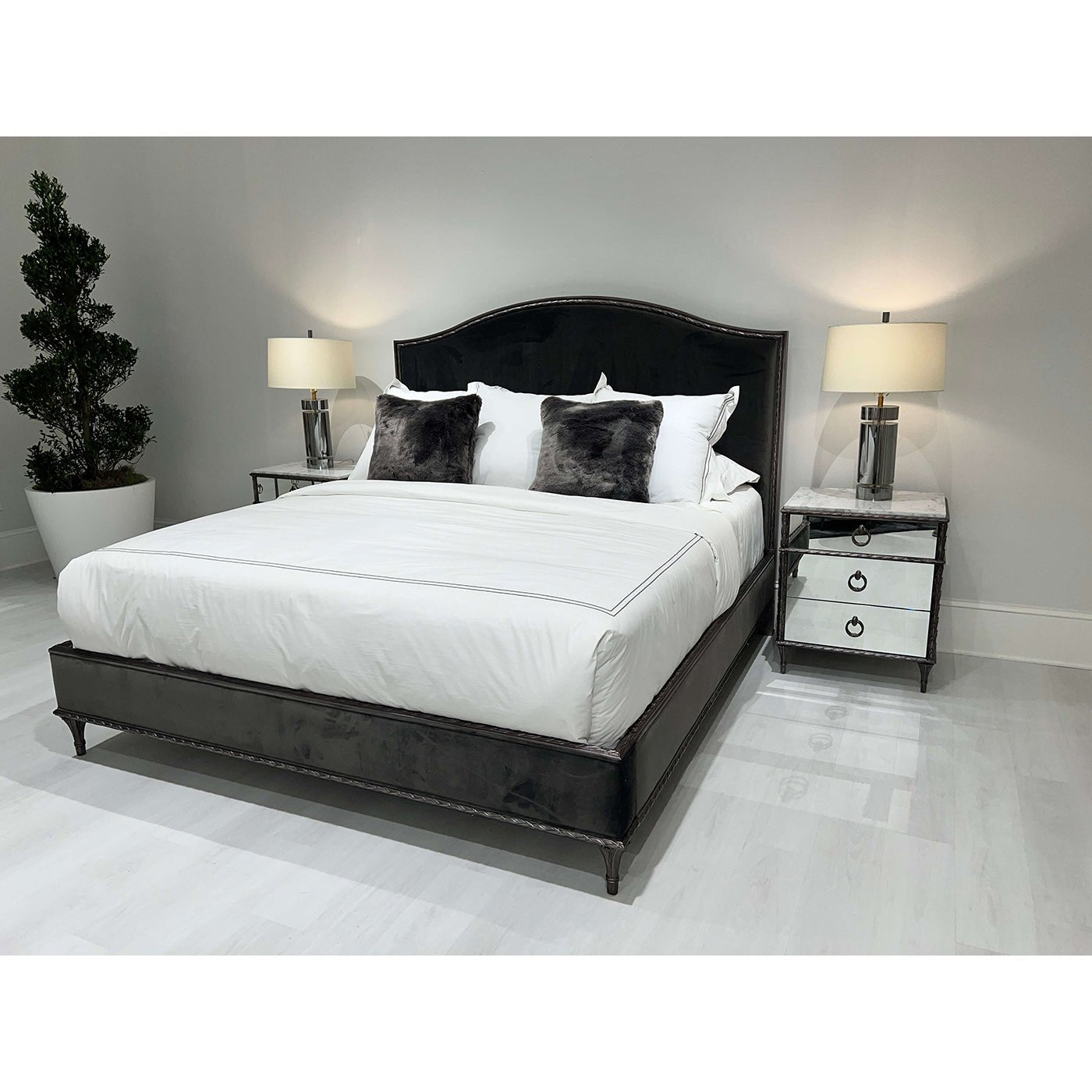 Bedroom with dual mirrored nightstands and stylish bedding.