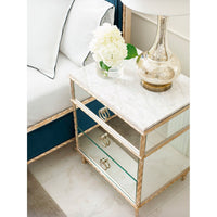 Gold nightstand in bedroom with decorative items.