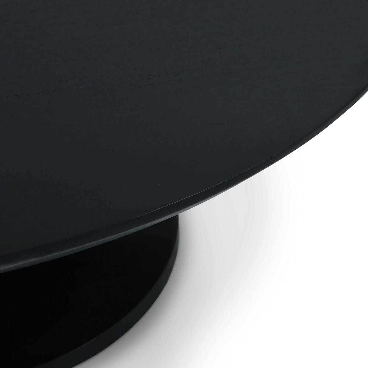 Side angle of sleek black tulip coffee table.