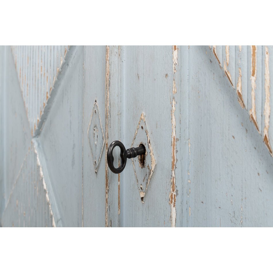Key in lock on blue sideboard door.