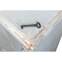 Antique key on blue painted sideboard corner.