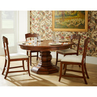 Round dining table with chairs and floral wallpaper.