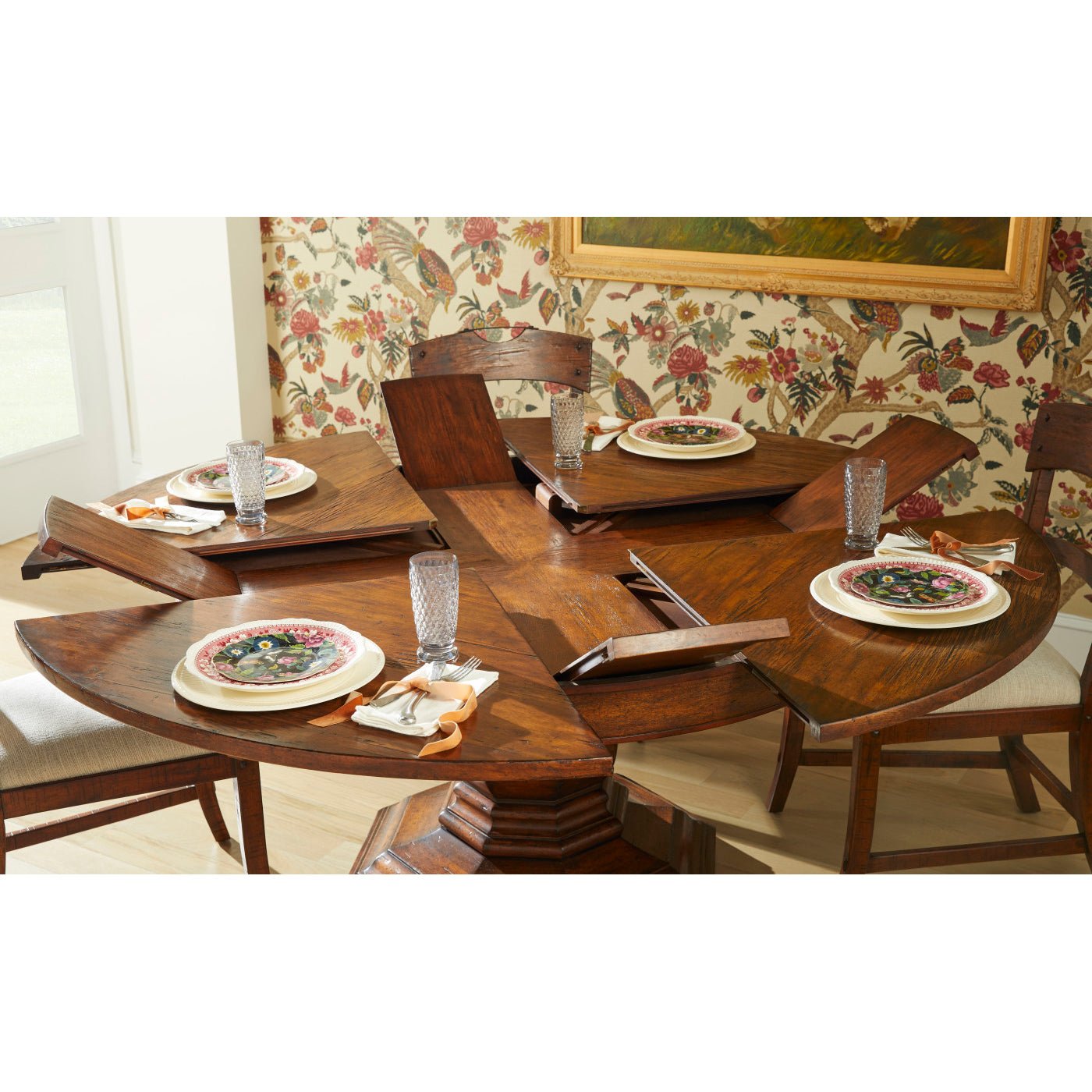 Side view of extended dining table with floral backdrop.