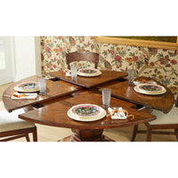 Partly extended round dining table with place settings.