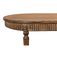 Close-up of carved details on oval dining table edge.