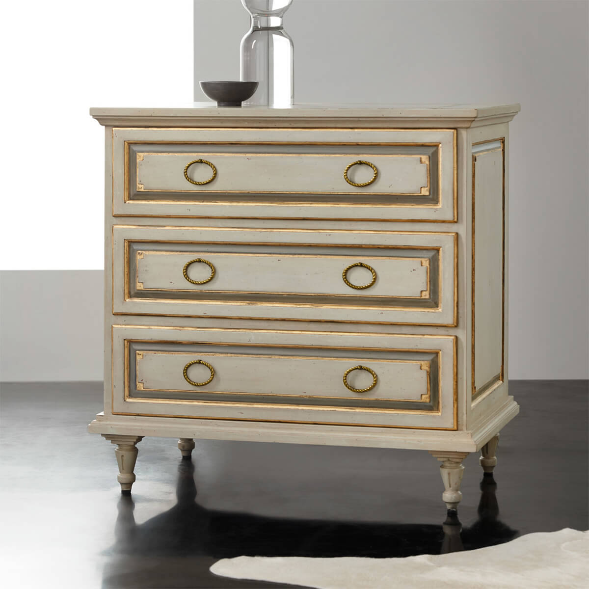 Elegant French nightstand on dark floor, front view.