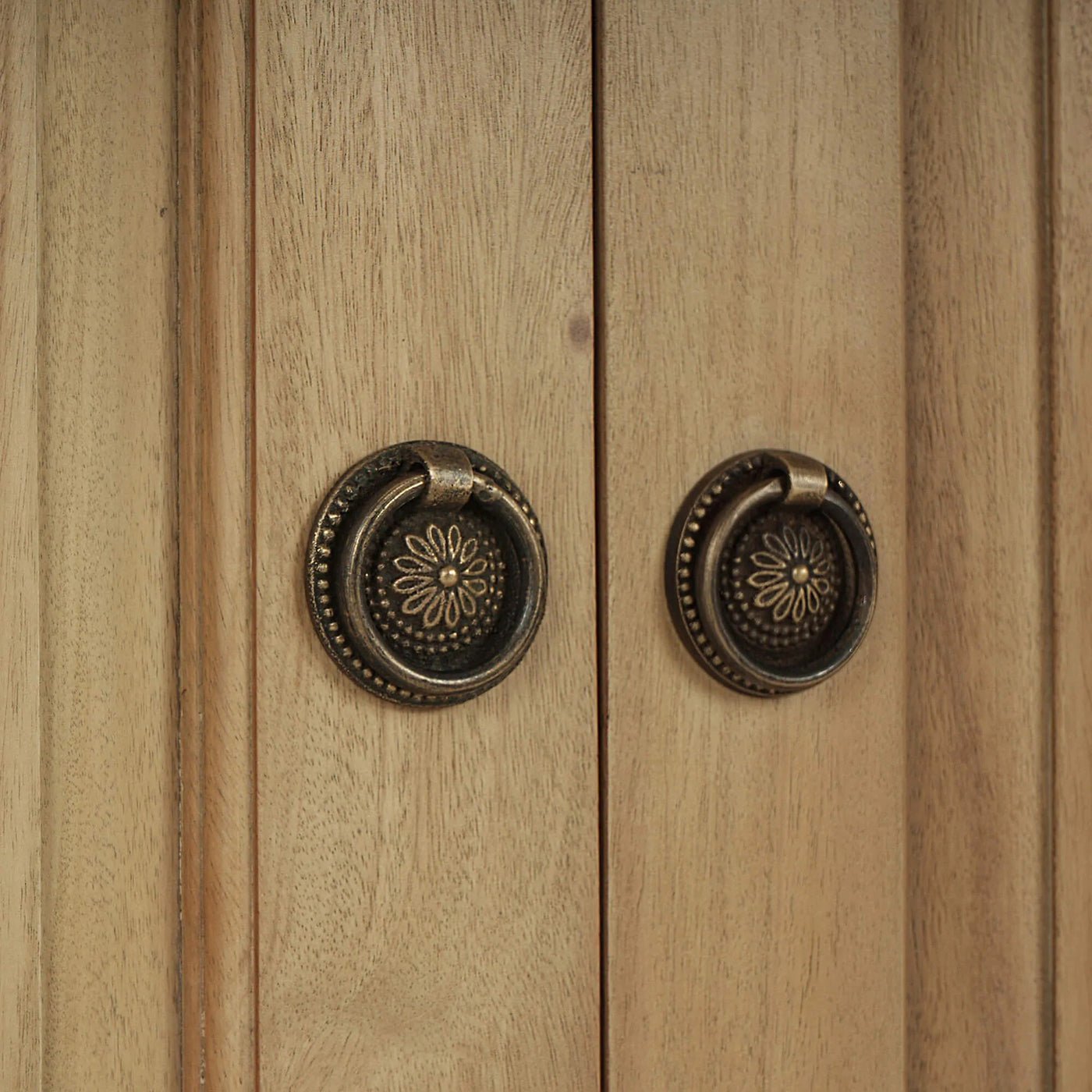 Close-up of ornate door handles on credenza.