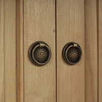 Close-up of ornate door handles on credenza.