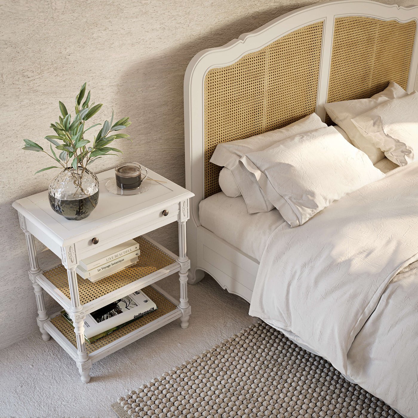 White end table next to bed with decor.