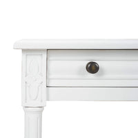 Close-up of carved detail on white end table.