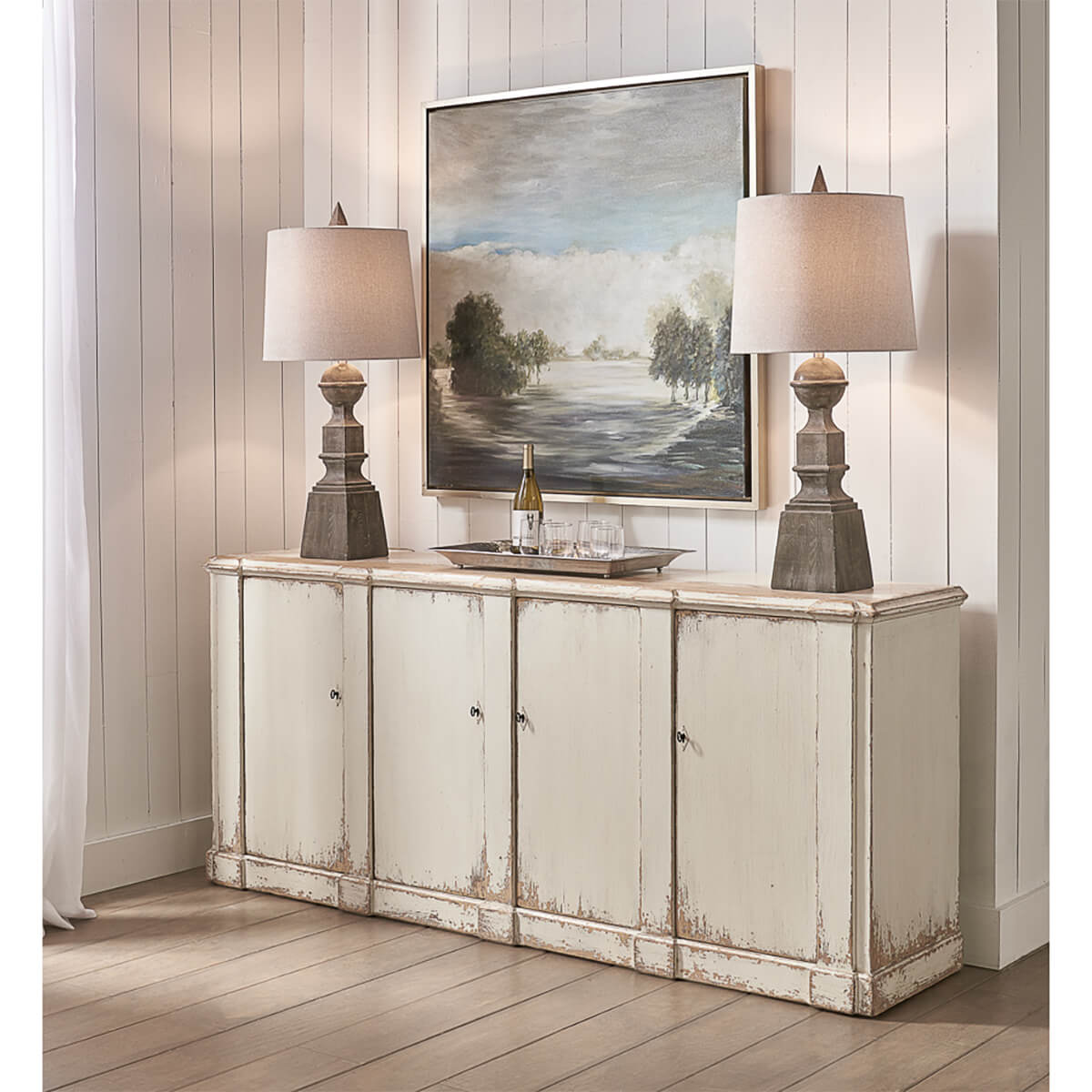 White sideboard styled with lamps and artwork.