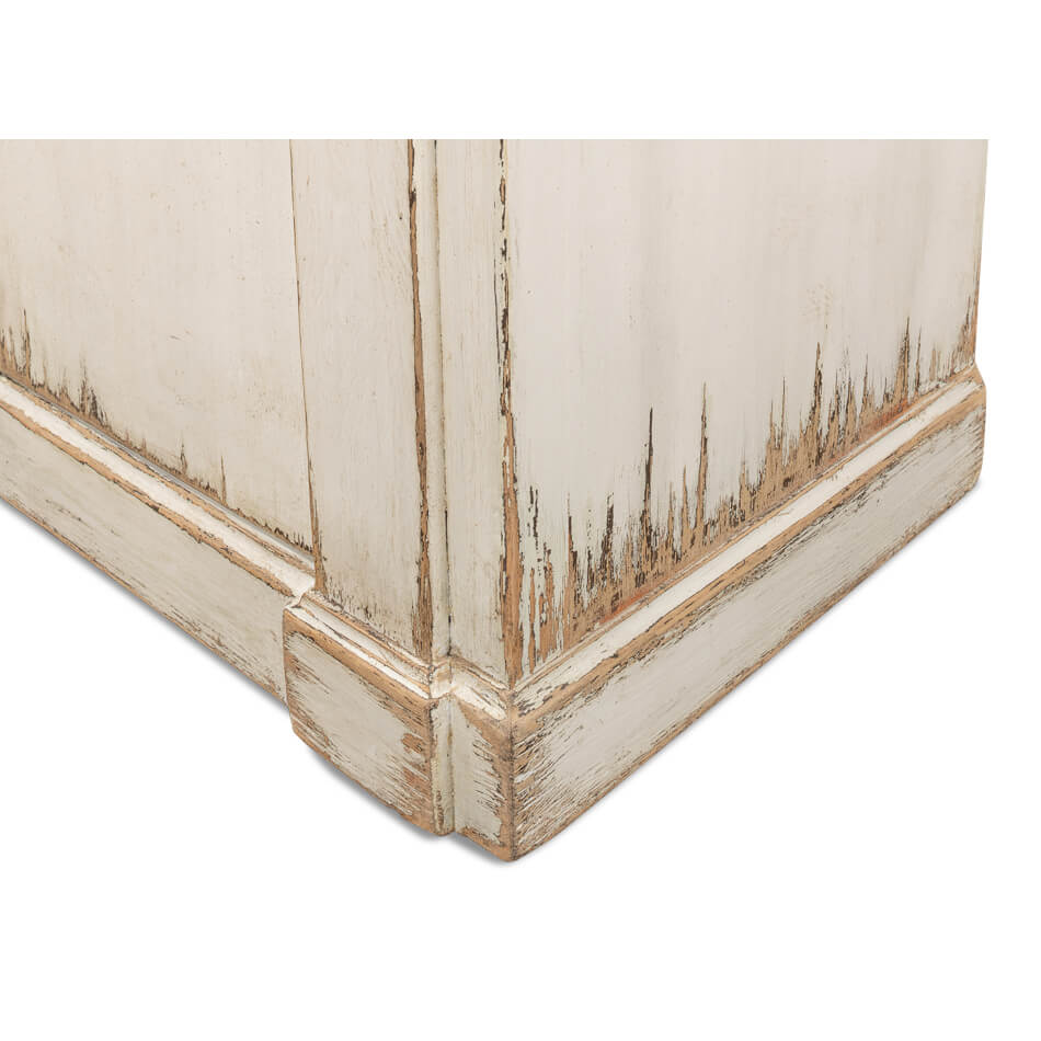 Corner detail of distressed white sideboard.