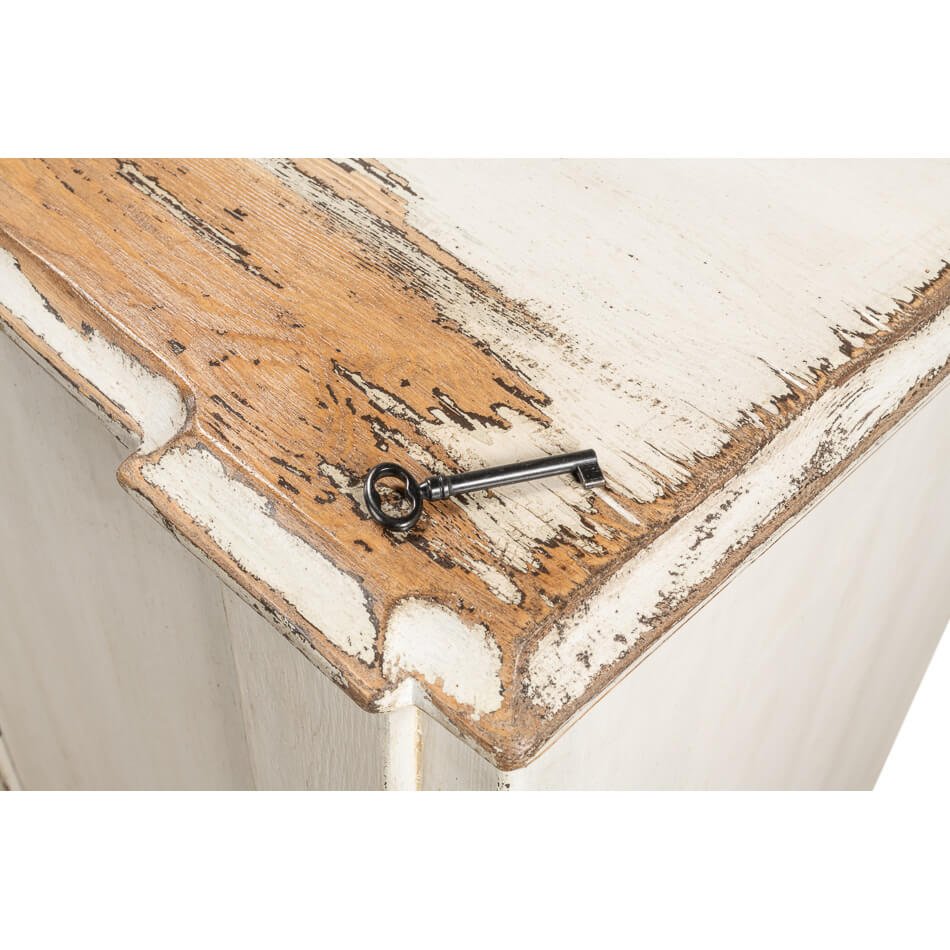 Key resting on distressed surface of sideboard.