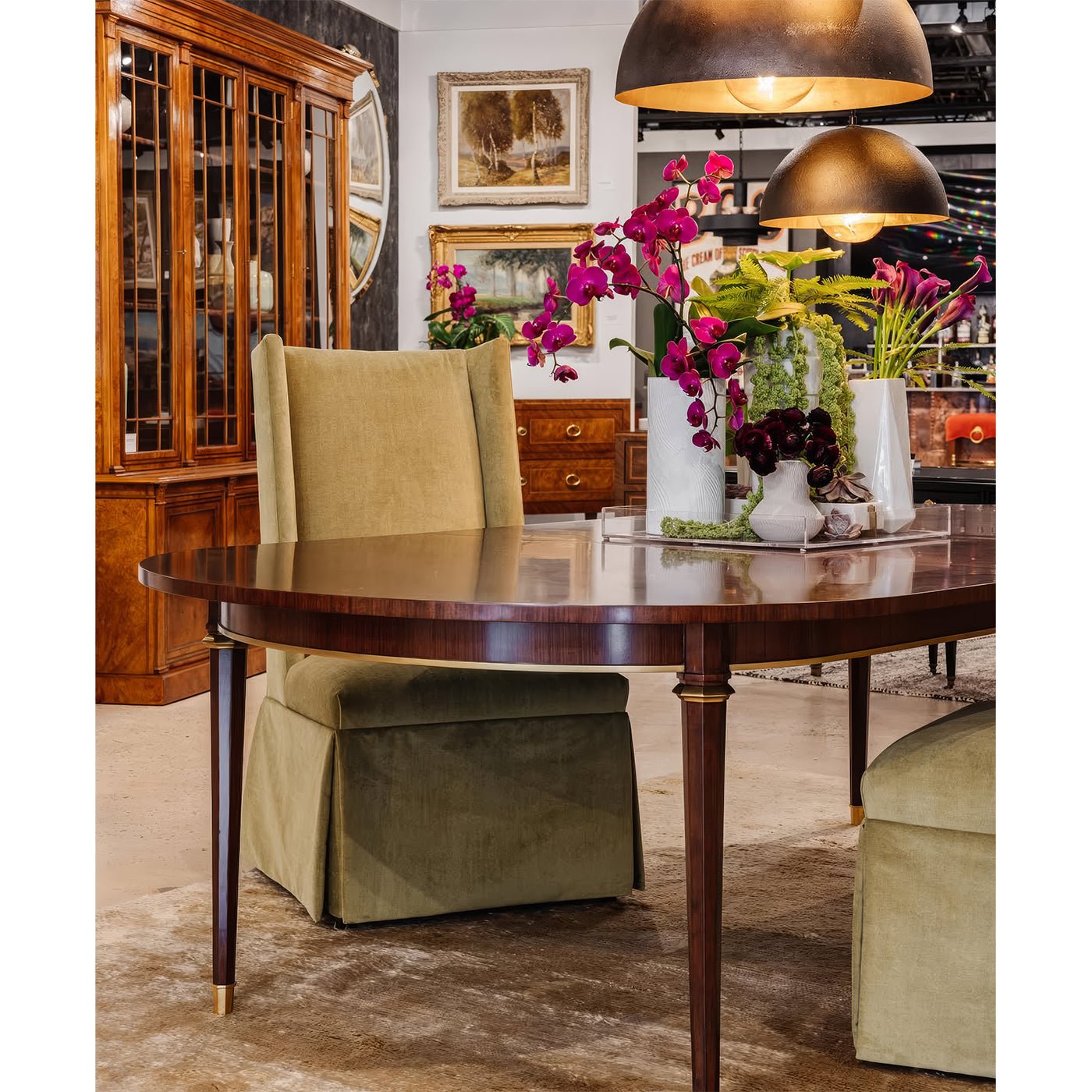 French walnut dining table with green chairs and decor.