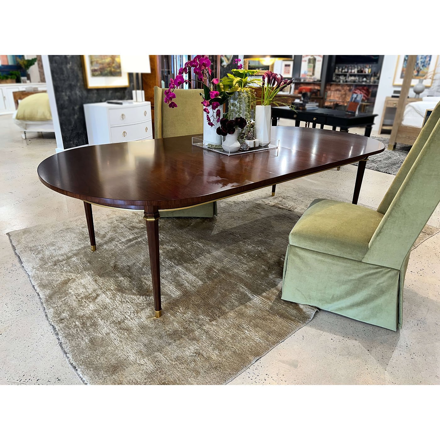 French walnut dining table in room with green chairs.
