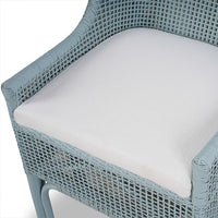 Close-up of cushioned seat on rattan dining chair.