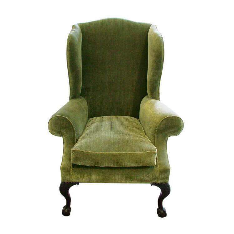 Green wing chair with carved ball and claw foot design.
