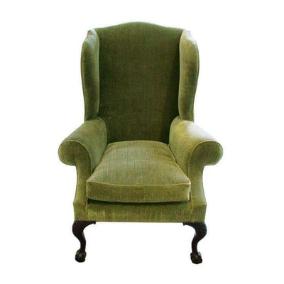 Green wing chair with carved ball and claw foot design.