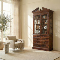 George II mahogany bookcase in room with armchair.