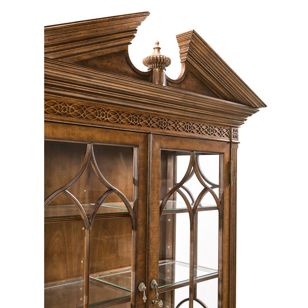 Close-up of ornate top detail on walnut bookcase.