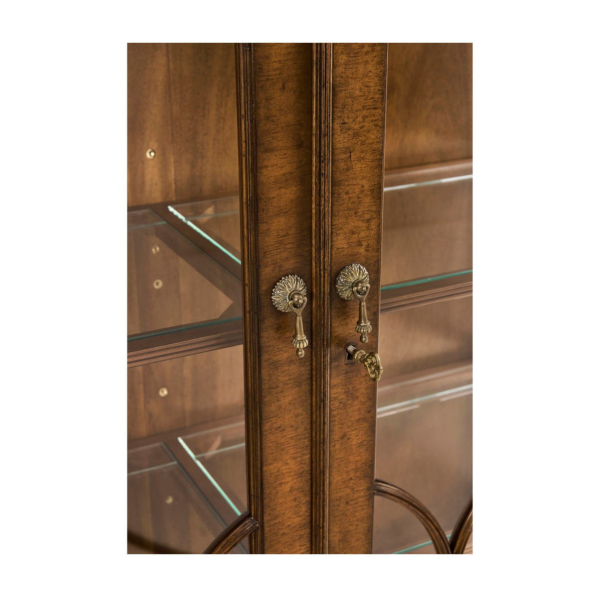 Close-up of door handles on walnut bookcase.