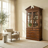 Walnut bookcase in living room setting, near chair.