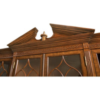 Close-up of decorative top on walnut display bookcase.