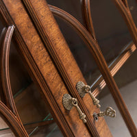 Close-up of ornate keys on walnut display bookcase.